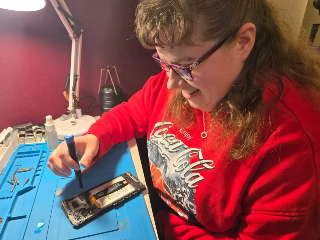 Bethany fixing a phone in the workplace gateway programme at whamos training and development